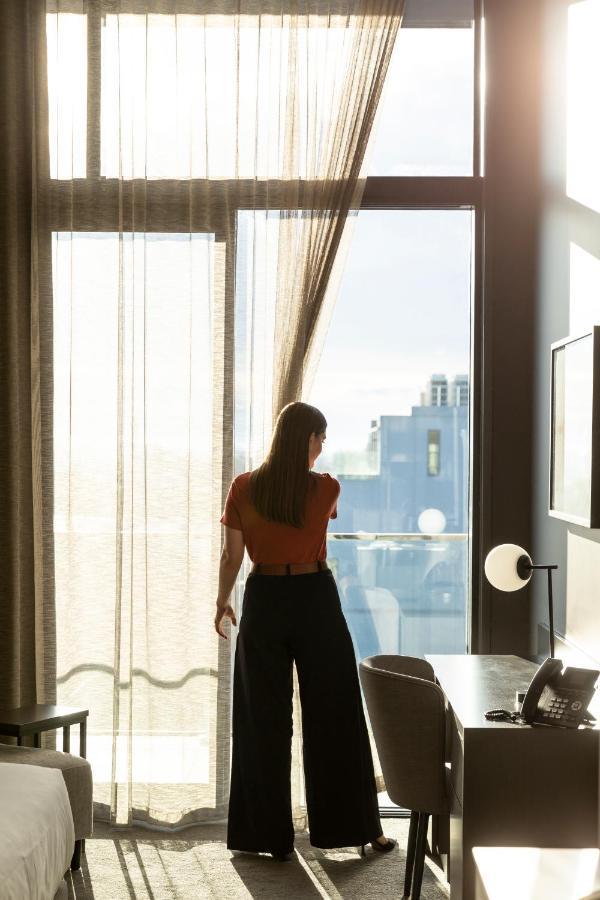 The Mayfair Christchurch Extérieur photo A woman opening a curtain